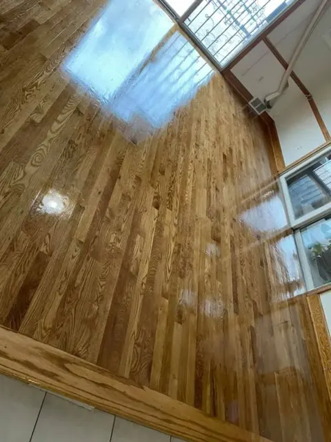 Polished hardwood floors reflecting natural light from large windows