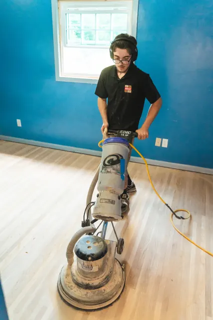 Monroe Floor Resurfacing crew member installing hardwood flooring in a local home
