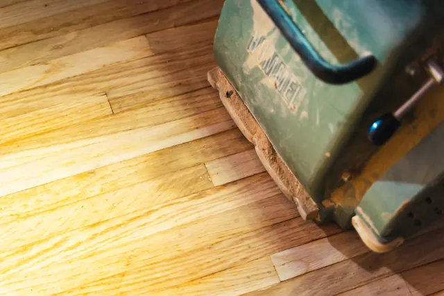 Side-by-side hardwood refinishing comparison showing before and after floor condition
